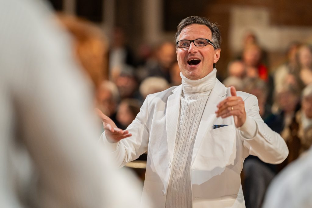 Der Chorleiter dirigiert den Chor mit Begeisterung